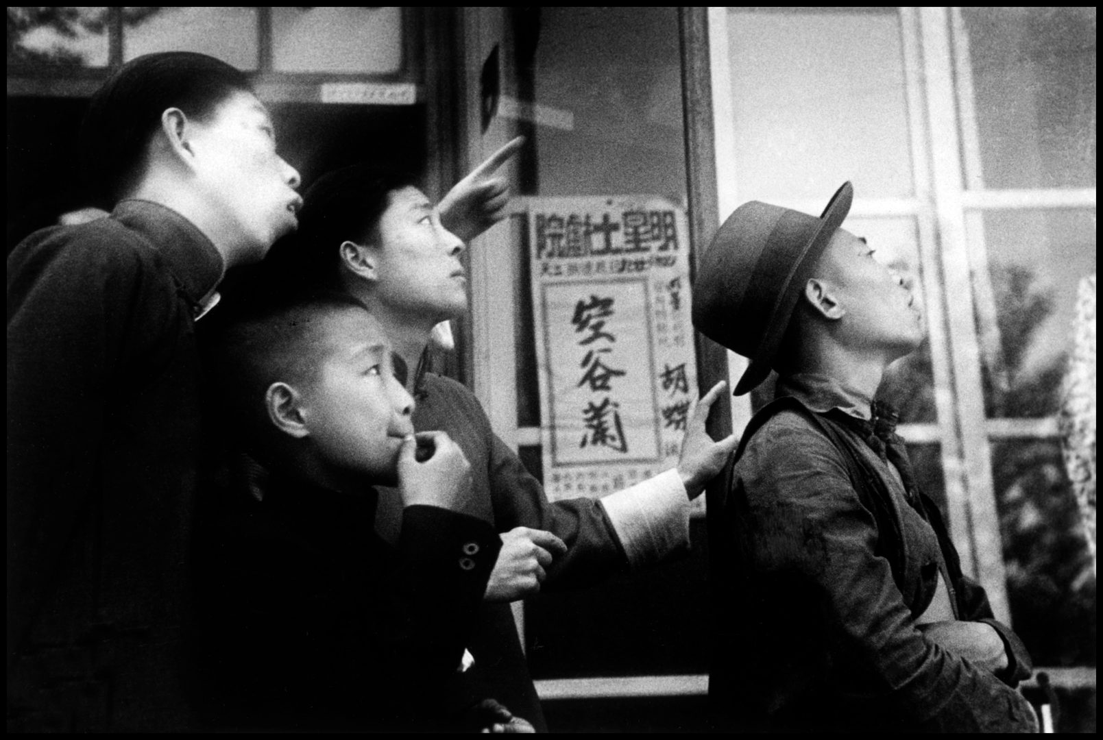 Chinese watching a battle between the Japanese bombers and the Chinese fighter planes on the day of Emperor Hirohito's birthday