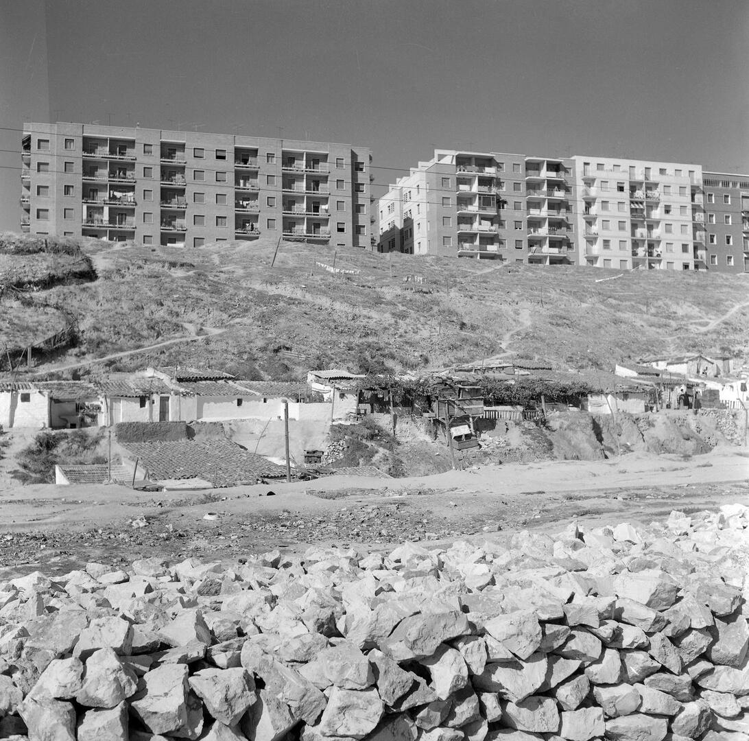 Chabolas junto a barricada de casas de nueva construcción en Madrid. 1965